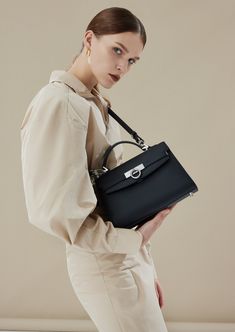 Inspired by Grace Kelly's enduring style, the Grace Top Handle Bag is meticulously crafted from premium USA full-grain textured calfskin leather, ensuring both durability and elegance. Its timeless and versatile design features a thoughtfully structured interior that comfortably accommodates all your everyday essentials. Whether day or night, you'll find yourself instinctively reaching for this chic and easy-to-wear masterpiece. Luxury Traditional Shoulder Bag With Top Carry Handle, Luxury Designer Top Handle Flap Bag, Luxury Classic Flap Bag With Metal Hardware, Luxury Taupe Shoulder Bag With Palladium Hardware, Luxury Top Handle Flap Bag, Luxury Flap Bag With Adjustable Strap For On-the-go, Luxury Top Handle Flap Bag With Palladium Hardware, High-end Calf Leather Shoulder Bag For Work, Office Flap Bag With Palladium Hardware And Top Handle