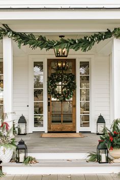 front porch decorated for christmas with wreaths and lanterns