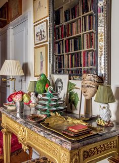 a room with a table, chair and bookshelf filled with lots of books