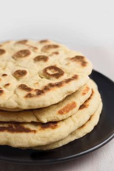 three pita breads on a black plate