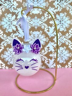 a white and purple cat ornament on a stand