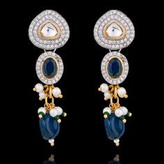 Dive into the symphony of blue elegance designed to make you feel like royalty! Adorn this one-of-a-kind jewelry set mesmerizing with radiant sapphire stones that beautifully complement different shades of blue beads along with sparkling CZ stones and delicate kundan accents with white and green moti, creating a spellbinding glow. The set includes a necklace and a pair of straight drop earrings. Approximate earrings length is 2". Pair our stunning Mohini Set with Nirali Bangles. Please click on Fusion Style Sapphire Jewelry, Fusion Style Blue Kundan Jewelry, Blue Traditional Earrings For Reception, Traditional Blue Earrings For Reception, Blue Fusion Style Jewelry For Wedding, Blue Gemstone Jewelry For Celebration, Blue Fusion Style Wedding Jewelry, Festive Fusion Blue Earrings, Blue Bollywood Jewelry With Stone Work