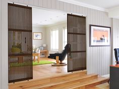 an open door leading to a living room with wood floors and white walls in the background