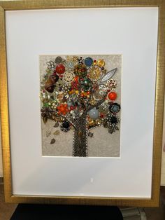 a tree made out of buttons in a frame