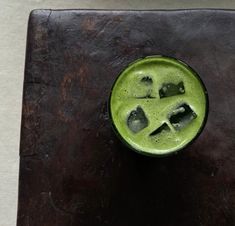 a green drink with ice cubes in it