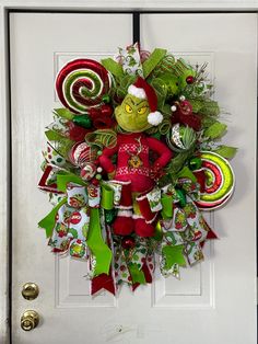 a christmas wreath is hanging on the front door with candy canes and candies