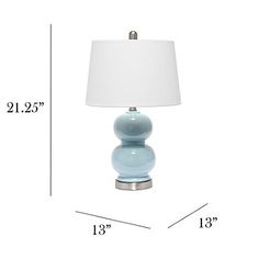 a blue table lamp sitting on top of a white floor next to a light shade