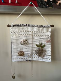 a crocheted wall hanging with various jewelry on it