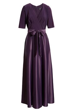 You'll be wrapped up oh so nicely in this lovely yet unconventional gown featuring a surplice V-neck and a full satin skirt topped off with a delightful bow. 59" length (size 8) Back zip closure Surplice V-neck Elbow-length sleeves Partially lined Top is 95% polyester, 5% spandex; skirt is 100% polyester Hand wash, dry flat Imported Women's Clothing Formal A-line Dress With Satin Bow, Elegant A-line Wrap Dress For Evening, Elegant Purple A-line Maxi Dress, Elegant Purple V-neck Gown, Elegant Evening Maxi Dress With Bow, Elegant V-neck Faux Wrap Dress, Fitted Satin Dress With Surplice Neckline For Formal Occasions, Fitted Satin Dress With Surplice Neckline For Formal Events, Elegant A-line Maxi Dress With Tie Waist