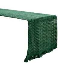 a green table runner with fringes on it