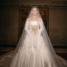 a woman in a white wedding gown and veil