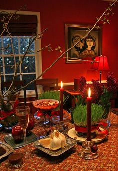 a dining room table with candles and dishes on it