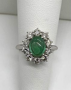 Beautiful estate genuine oval cabochon cut emerald and natural diamonds in solid 18k white gold. Emerald is prong set in the center of the ring is an A quality 8.5x6.5 mm. and 1CTW.  Has a few natural features like veins, a cloud and some dark inclusions.  Diamonds all prong set, there are 10 round cut stones 1.2 TCW F-G color, VS2-SI1 clarity. Will fit 5.75 US finger size. Truly beautiful ring. Was appraised by 3rd party independent GIA graduate jeweler.  Please ask any questions you might have. Thank you. Exquisite Oval Platinum Gemstones, Emerald Cabochon Ring With Diamonds, Gia Certified Oval Emerald Gemstone, Gia Certified Oval Emerald, Hallmarked Oval Emerald Ring In Platinum, Oval Hallmarked Emerald Ring In Platinum, Luxury White Gold Oval Cabochon Emerald Ring, Oval Brilliant Cut Emerald Gemstones, Oval Emerald Gemstones With Halo Setting