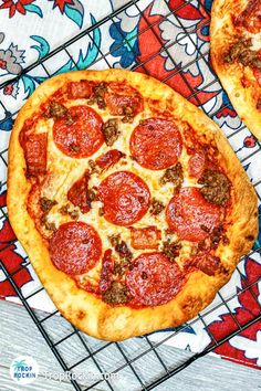 two pepperoni pizzas sitting on top of a cooling rack