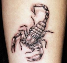 a black and white scorpion tattoo on the leg