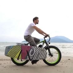 a man is riding his bike on the beach