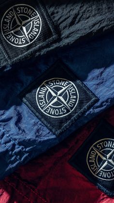 two patches on the side of a blue and red jacket that says stone island snow patrol