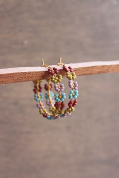 "Seed beads woven with wire onto a brass hoop making a circle of tiny, delicate flowers. This hoop measures 1.25\" in diameter.  **Please note that colors may vary slightly due to difference in monitor and phone screens**" Bead Hoop Earrings, Seed Bead Earring, Beaded Hoops Earrings, Beaded Flower Earrings, Handmade Beaded Jewelry, Beaded Earrings Patterns, Beaded Hoop Earrings, Beaded Hoops, Beaded Accessories