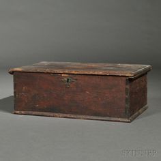 an old wooden box sitting on top of a gray floor next to a white wall