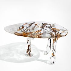 an artistically designed glass table with water dripping from the top, on a white background