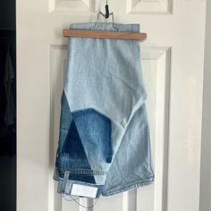 a pair of blue jeans hanging on a door