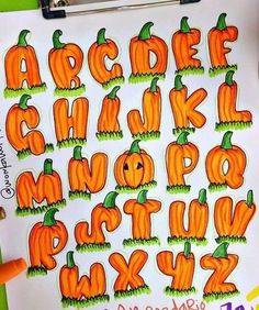 an alphabet made out of pumpkins on a white paper with marker pens and markers