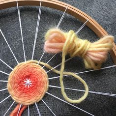 a close up of yarn and scissors on top of a spinning wheel with spokes