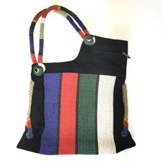 a multicolored handbag hanging on a white wall