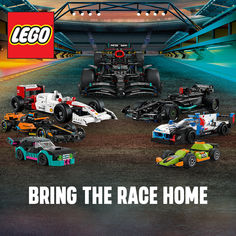 a group of lego race cars sitting on top of a dirt road in front of a stadium