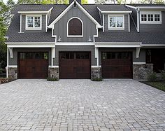 a large house with two garages and brick driveway