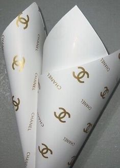 three white envelopes with gold logos on them sitting next to each other in a room