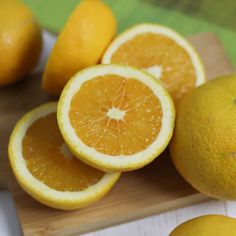 several oranges cut in half on a cutting board