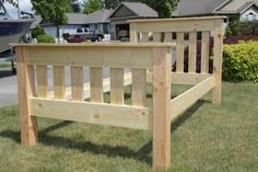 a wooden bed frame sitting in the grass