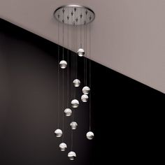 a chandelier hanging from the ceiling in a room with black walls and flooring