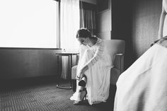 a woman sitting in a chair with her foot on the floor next to a window