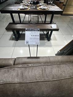 a table with two benches and a sign on it for sale in a store setting