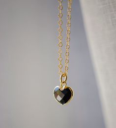 "Crafted onto a 14k gold filled chain and set in 24k gold electroplate, this black onyx heart is as precious as the affection it symbolizes. Make it that perfect gift for someone special, including yourself! Exuding protective and calming energies, Black Onyx is associated with the root chakra. It's believed to be an \"anti-panic\" stone which soothes stress and helps clear mental confusion and hyperactivity. GEMSTONE: Black Onyx STONE SIZE: average 10mm (.39\")  STONE SHAPE: Faceted Heart (Hear Black Heart-shaped Jewelry For Anniversary, Elegant Black Heart Necklace With Adjustable Chain, Black Gold-plated Adjustable Chain Jewelry, Minimalist Black Heart Jewelry, Minimalist Black Heart-shaped Jewelry, Black Sterling Silver Jewelry For Valentine's Day, Dainty Heart Shaped Black Jewelry, Dainty Black Heart-shaped Jewelry, Dainty Black Heart Jewelry