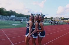 two cheerleaders hugging each other on a track