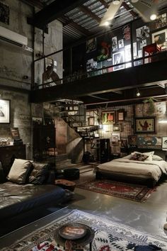 an industrial loft with exposed ceilings and lots of furniture in the living room, including a bed