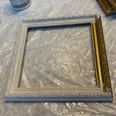 an empty frame sitting on top of a table covered in plastic