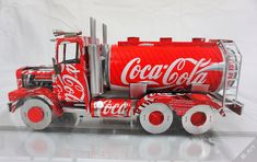 a coca - cola truck is displayed on a white surface