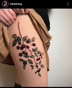 a woman's thigh with berries and leaves on it