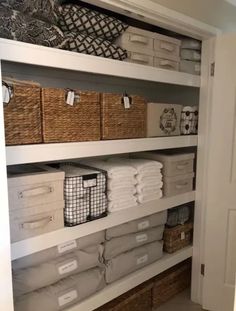 an organized closet with baskets and towels