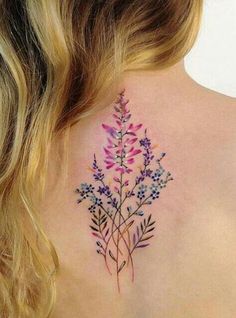 the back of a woman's neck with purple flowers on her left shoulder and chest