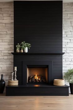 a fireplace with a black mantle and white brick wall behind it, surrounded by potted plants