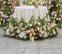 a table with flowers and candles is set up for an outdoor wedding reception in the garden