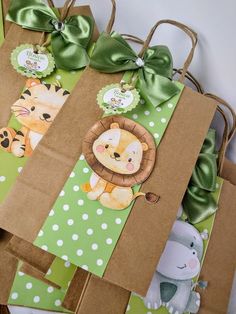 some brown paper bags with green bows and animals on them are sitting next to each other