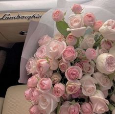 a bouquet of pink roses sitting in the back seat of a car