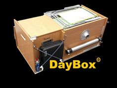 a wooden box with an electronic device in it's compartment and the words daybox below it