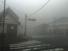 an intersection in the fog with traffic lights